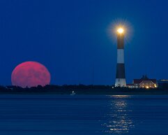 super-moon Super moon rising as the Fire Island lighthouse stands on the foreground